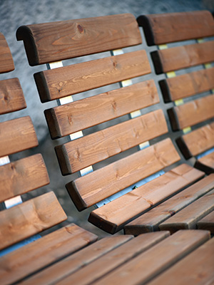 Close up of wooden park chairs with backrests.